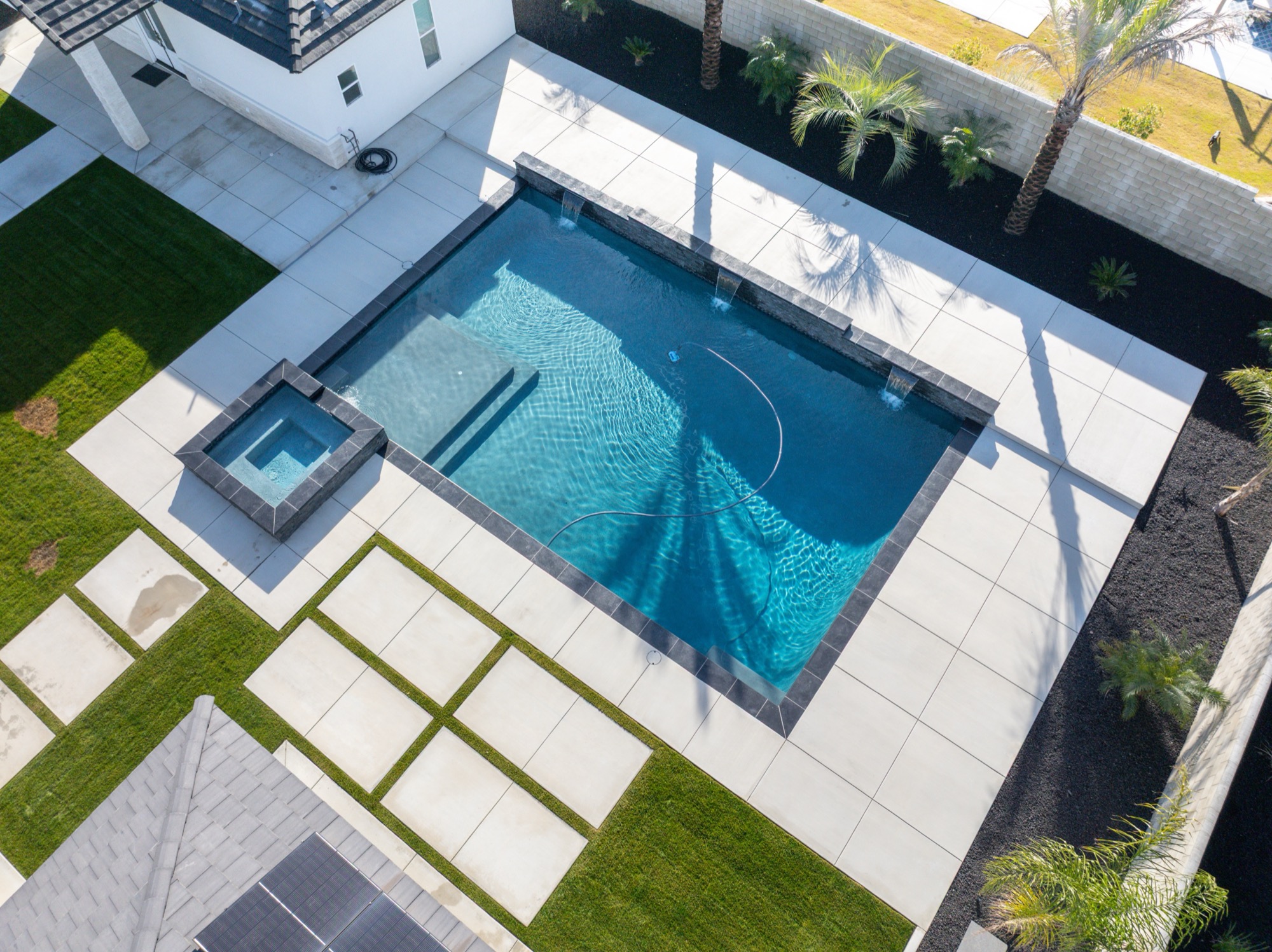 Aerial view of custom gunite pool with modern white home — Bakersfield, CA