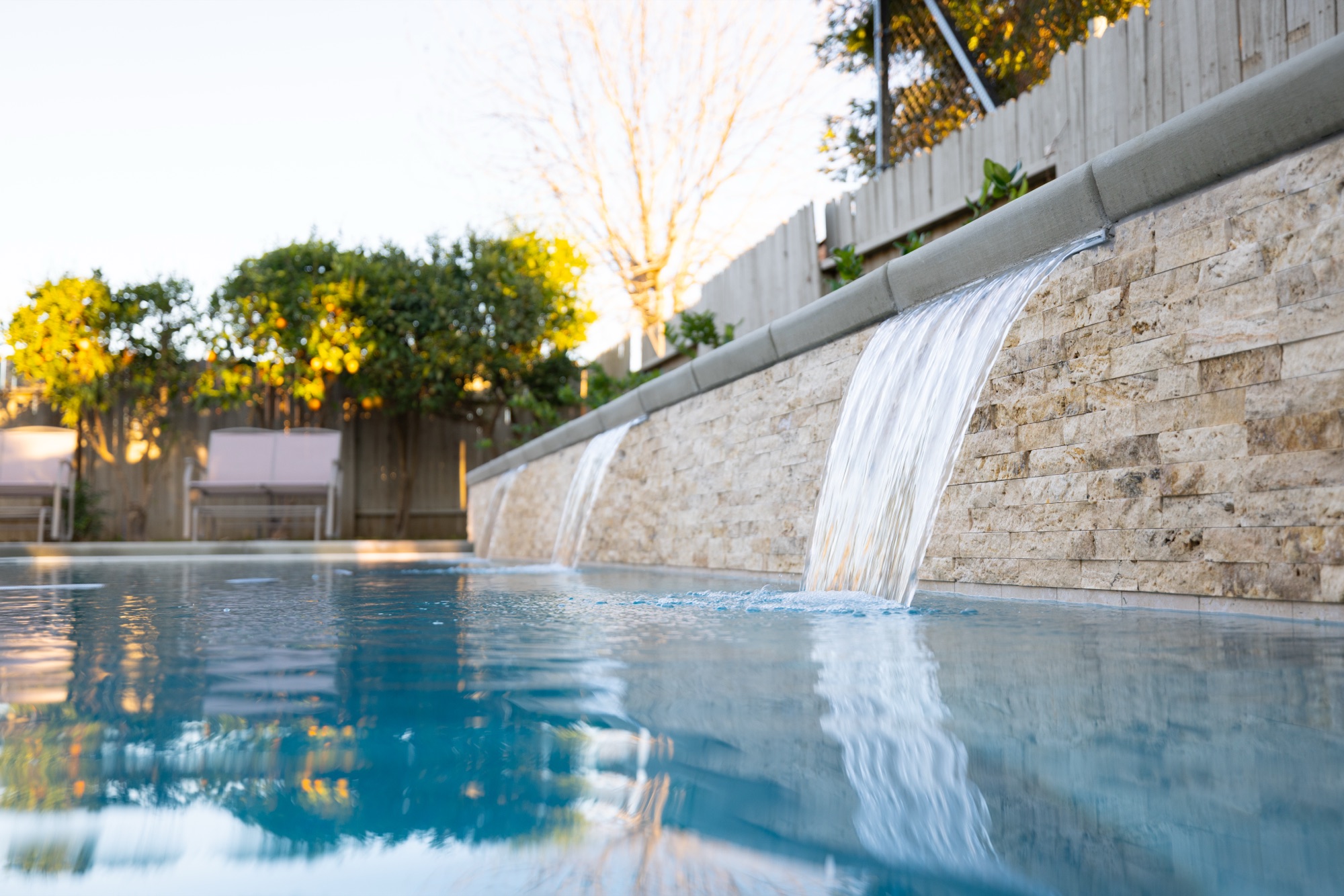 Stone wall waterfall detail on custom gunite pool — Bakersfield, CA